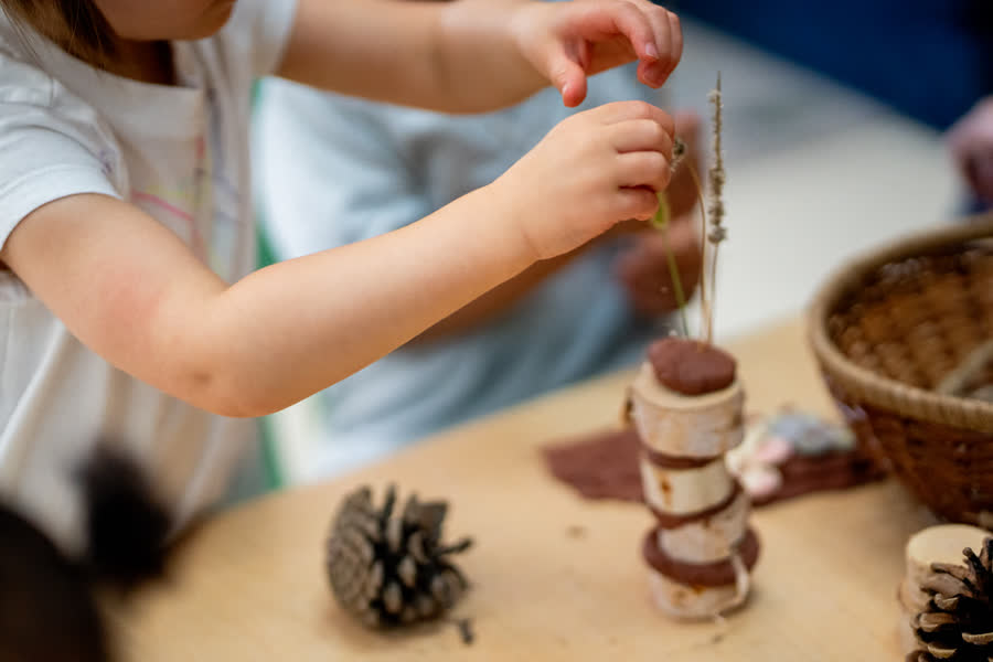 Des mains construisent des tours d'argile et de bois