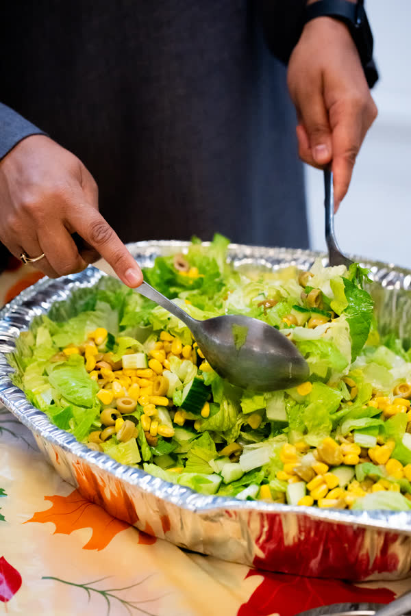 Une éducatrice sert une salade de maïs