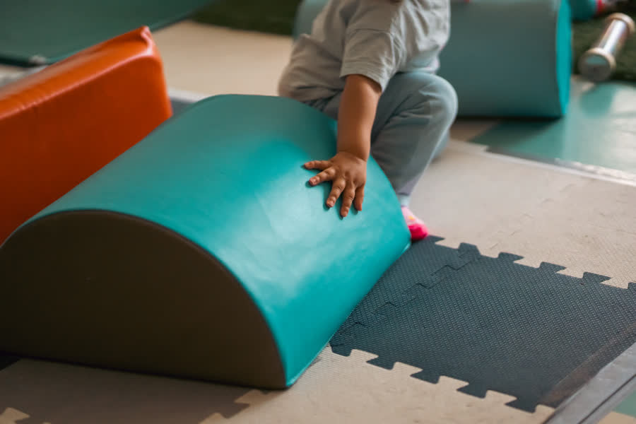 Un bébé grimpe sur des blocs de mousse